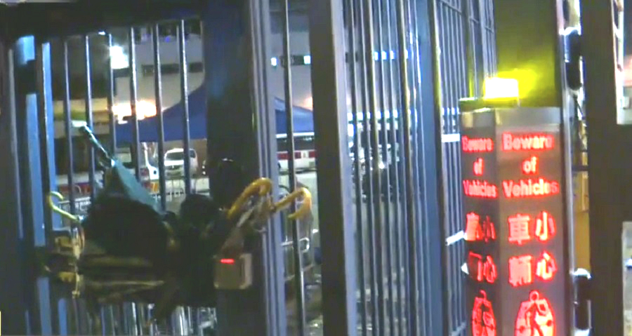 防暴警退回警署後,示威者用雨傘頂著鐵閘。有線新聞截圖