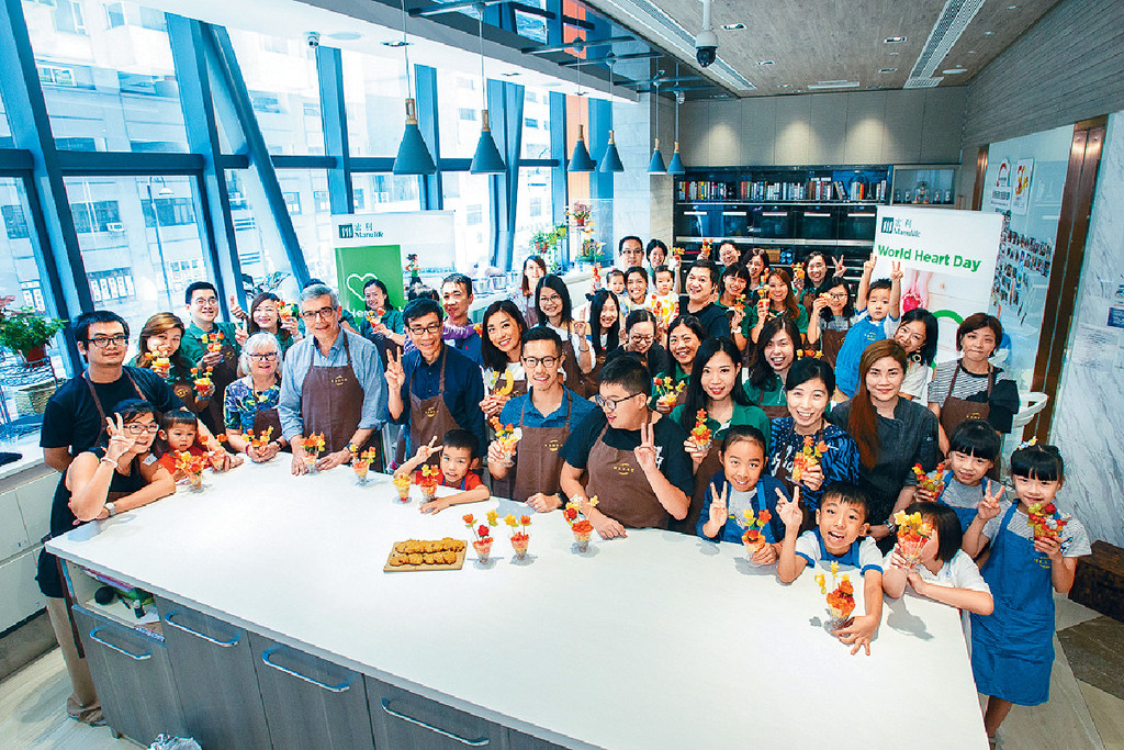 ■健康烹飪班上，宏利香港首席行政總監萬士家（前排左四）與大家一起製作健康食品。