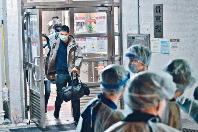 ■穿上防護裝備的警員及衞生署人員,協助二十三樓以上的一五室居民撤離,前往檢疫中心。