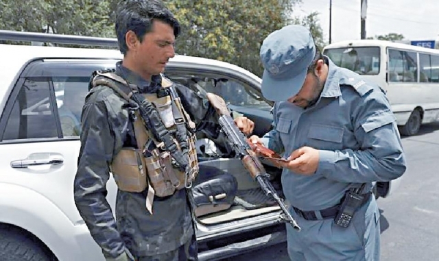 ■阿富汗警方檢查持槍人士的證件。美聯社