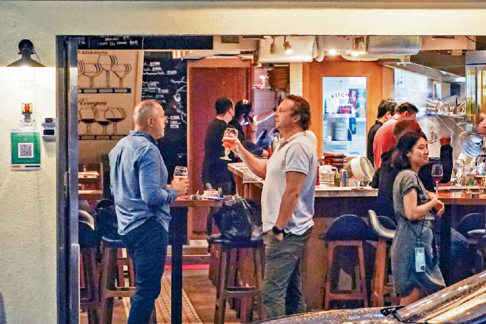 ■西環邨對開餐廳如常營業，有客人除罩舉杯聊天。