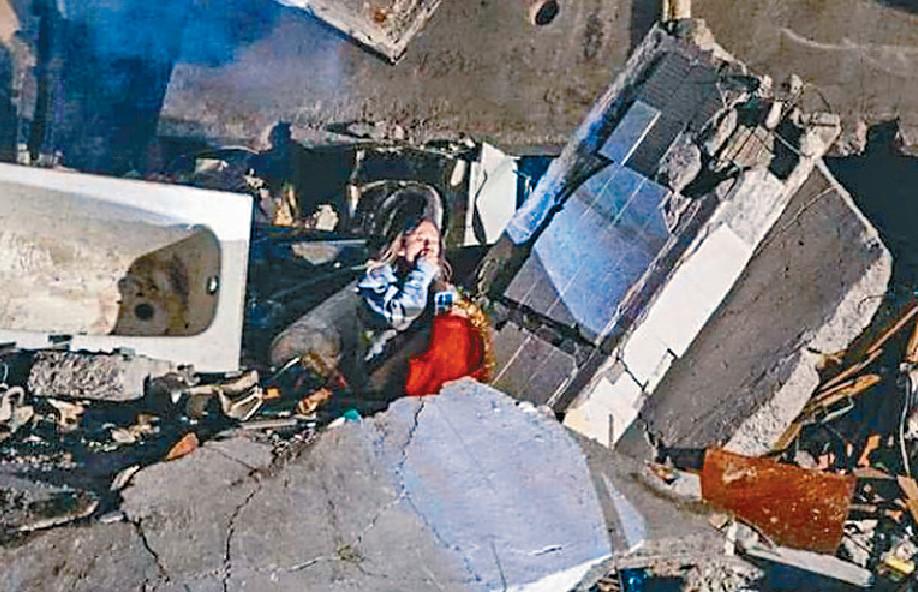 ■網絡流傳一張圖片，公寓中央炸出一大空洞，當中有一年輕女子存活，坐在瓦礫堆中哭泣。